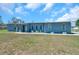 Charming single-story home with a light blue exterior, well-maintained lawn, and neatly trimmed landscaping at 10722 Sumner Rd, Wimauma, FL 33598