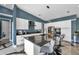 Modern kitchen boasts waterfall island with seating, sleek white cabinetry, and contemporary finishes at 10722 Sumner Rd, Wimauma, FL 33598
