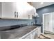 Well-appointed laundry room with black countertops, white cabinets, and modern appliances at 10722 Sumner Rd, Wimauma, FL 33598