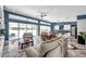 Bright, open living room with modern lighting, high ceilings, expansive windows, and an elegant tile floor at 10722 Sumner Rd, Wimauma, FL 33598