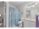 Bathroom with a colorful shower curtain, white vanity, and ample lighting at 10764 70Th Ave # 3206, Seminole, FL 33772