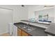 Open kitchen area featuring a stainless steel sink, granite countertops, and bar seating at 10764 70Th Ave # 3206, Seminole, FL 33772