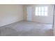 Spacious bedroom with plush carpeting, neutral walls, and a bright window at 111 Lakeview Pl, Oldsmar, FL 34677