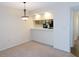 Dining area with neutral carpeting and a view into the kitchen area and its appliances at 111 Lakeview Pl, Oldsmar, FL 34677