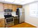 Bright kitchen with wood floors, wooden cabinets, and stainless steel appliances at 111 Lakeview Pl, Oldsmar, FL 34677