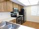 Well-lit kitchen with stainless steel appliances, light countertops, and wood-look flooring at 111 Lakeview Pl, Oldsmar, FL 34677