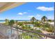 Balcony view showcasing lush tropical landscaping and a tranquil pool area leading to the beach at 1180 Gulf Blvd # 402, Clearwater Beach, FL 33767