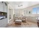Bright living room with custom cabinetry, comfortable seating, and views of the beach and pool through plantation shutters at 1180 Gulf Blvd # 402, Clearwater Beach, FL 33767