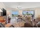Comfortable living room featuring large windows with ocean views, a ceiling fan, and classic furnishings at 1180 Gulf Blvd # 402, Clearwater Beach, FL 33767