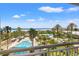 Amazing view of the pool and beach from the balcony, surrounded by palm trees and lush landscaping at 1180 Gulf Blvd # 402, Clearwater Beach, FL 33767