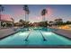 Stunning swimming pool at dusk lined with palm trees and elegant cabanas at 1180 Gulf Blvd # 402, Clearwater Beach, FL 33767