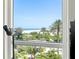 Beautiful view of the beach and ocean from the condo window, complete with palm trees and lush landscaping at 1180 Gulf Blvd # 402, Clearwater Beach, FL 33767