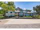 Condo exterior with parking area, lush greenery, and mature trees at 11800 Park Blvd # 208, Seminole, FL 33772