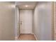 Hallway with tiled floor leading to a white six-panel front door at 11800 Park Blvd # 208, Seminole, FL 33772