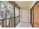 Screened patio features black metal railing and tiled floors with view of mature trees at 11800 Park Blvd # 208, Seminole, FL 33772