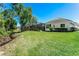 Large backyard with lush green grass and view of screened-in pool area at 11938 Royce Waterford Cir, Tampa, FL 33626