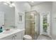 Bathroom featuring a glass-enclosed shower, light tile, vanity with modern fixtures, and neutral paint at 11938 Royce Waterford Cir, Tampa, FL 33626
