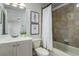Cozy bathroom featuring a shower-tub combo, tiled walls, and a vanity with a white countertop at 11938 Royce Waterford Cir, Tampa, FL 33626