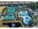 Aerial view of community amenities including tennis courts, a pool, and clubhouse surrounded by landscaping, offering a rich lifestyle at 11938 Royce Waterford Cir, Tampa, FL 33626