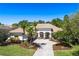 Beautiful Mediterranean-style home with a tile roof, lush landscaping, and a circular driveway, showcasing curb appeal at 11938 Royce Waterford Cir, Tampa, FL 33626