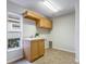 Well-lit laundry room featuring a utility sink, ample cabinet space and tile flooring at 11938 Royce Waterford Cir, Tampa, FL 33626