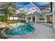 Screened in pool area with brick patio, outdoor kitchen, and access to the main house, ideal for outdoor living at 11938 Royce Waterford Cir, Tampa, FL 33626