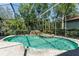 Screened in pool area featuring rock waterfall and spa surrounded by well maintained landscaping, perfect for relaxation at 11938 Royce Waterford Cir, Tampa, FL 33626