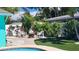 Landscaped backyard with manicured lawn, hedges, and a cozy brick patio fire pit area at 12176 Croft Dr, Largo, FL 33774