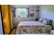 Comfortable bedroom with a large window, patterned bedding, and wood-look flooring at 12176 Croft Dr, Largo, FL 33774