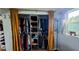 Organized closet with hanging clothes, shelves, and framed by elegant gold curtains at 12176 Croft Dr, Largo, FL 33774