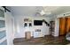 Open-concept living room with a modern ceiling fan, TV, and decorative shelving at 12176 Croft Dr, Largo, FL 33774