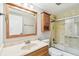 Updated bathroom with wooden vanity, framed mirror, and shower at 13501 Palmwood Ln # 0, Tampa, FL 33618