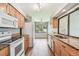 Open kitchen layout with wooden cabinets, granite countertops, and modern white appliances at 13501 Palmwood Ln # 0, Tampa, FL 33618