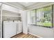 Functional laundry room with modern washer, dryer and white storage shelves at 13501 Palmwood Ln # 0, Tampa, FL 33618