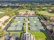 Aerial view of community tennis courts with lush landscaping, multiple courts, and a nearby pond and golf course at 13501 Palmwood Ln # 0, Tampa, FL 33618