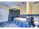 Luxurious bathroom features a soaking tub with a glass-enclosed shower and blue-tiled floor at 13635 Twin Lakes Ln # 13635, Tampa, FL 33618