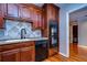 The kitchen features wood cabinets, granite countertops, stainless steel appliances, and a stylish backsplash at 13635 Twin Lakes Ln # 13635, Tampa, FL 33618