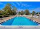 Community pool with brick pavers, plenty of seating, and a clear blue sky above at 13635 Twin Lakes Ln # 13635, Tampa, FL 33618