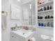 Bright bathroom features a sink with a gold faucet, marble-look countertops, and shelving for storage at 1406 Valley Pl, Brandon, FL 33510
