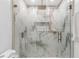 A well-lit bathroom features a shower with a glass door and marble-look tiles at 1406 Valley Pl, Brandon, FL 33510