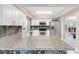 Updated kitchen featuring white cabinets, stainless steel appliances, marble floors, and granite countertops at 1406 Valley Pl, Brandon, FL 33510