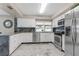 Bright kitchen with white cabinets, stainless steel appliances, granite countertops, and marble floors at 1406 Valley Pl, Brandon, FL 33510