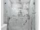 Elegant walk-in shower featuring marble tile, glass enclosure, and built-in shelving at 1406 Valley Pl, Brandon, FL 33510