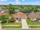 An aerial shot showcasing this well-maintained home with a two-car garage, complemented by lush green surroundings at 14103 Stonebrook Ct, Tampa, FL 33624