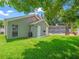 View of home exterior from lush green lawn leading to screened-in pool at 14103 Stonebrook Ct, Tampa, FL 33624