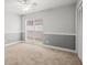Bedroom featuring gray walls, wall trim, a closet, a large window, and neutral colored carpet flooring at 14103 Stonebrook Ct, Tampa, FL 33624