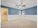 Bedroom featuring wainscoting, two windows, a ceiling fan, blue wall paint, and carpet flooring at 14103 Stonebrook Ct, Tampa, FL 33624