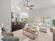 Open concept living room with comfortable seating, ceiling fan, and access to the pool area at 14103 Stonebrook Ct, Tampa, FL 33624