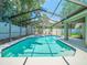 Sparkling screened-in pool with bright blue tiling, set in a peaceful, private backyard perfect for relaxation at 14103 Stonebrook Ct, Tampa, FL 33624