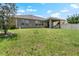 Spacious backyard featuring lush green grass, a covered patio, privacy fencing, and mature landscaping at 1517 Yale Castle Ct, Ruskin, FL 33570